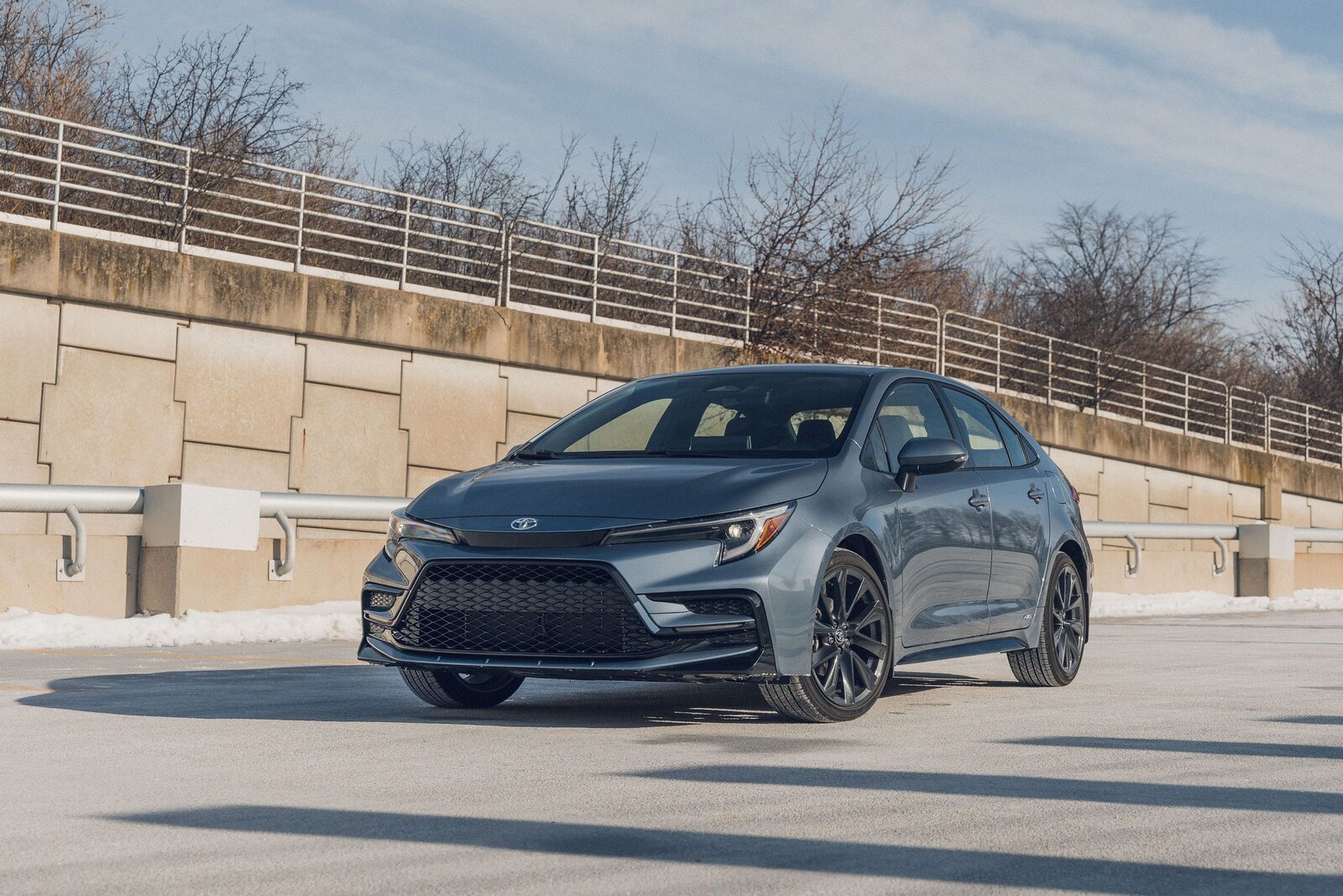 Серо-голубая Toyota Corolla на парковке, вид спереди-сбоку